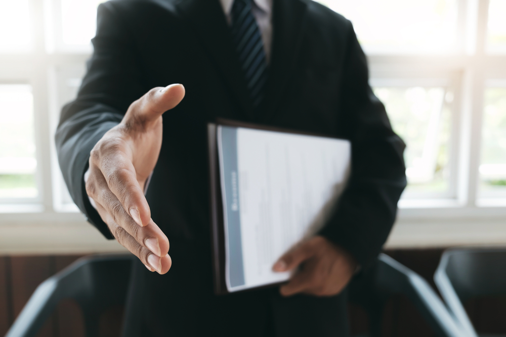 A man offering a handshake in the office.