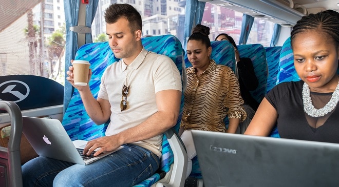 commuters on zeelo luxury bus in traffic