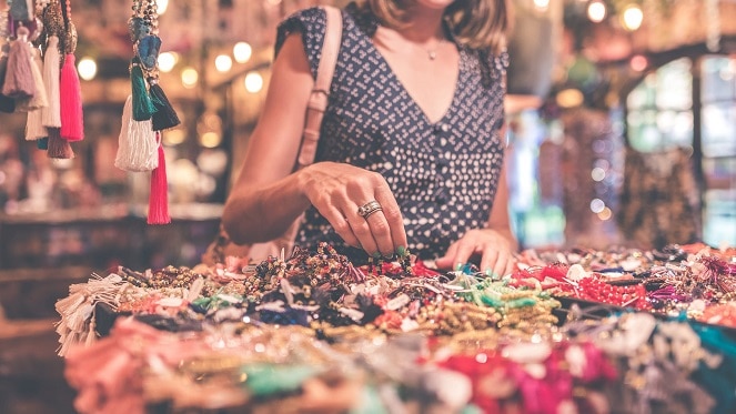 lady shopping at a market looking at colourful jewellery