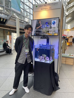 &nbsp;Innoqua employee Kyousuke Matsuura photographed alongside an aquarium with corals developed by the startup.