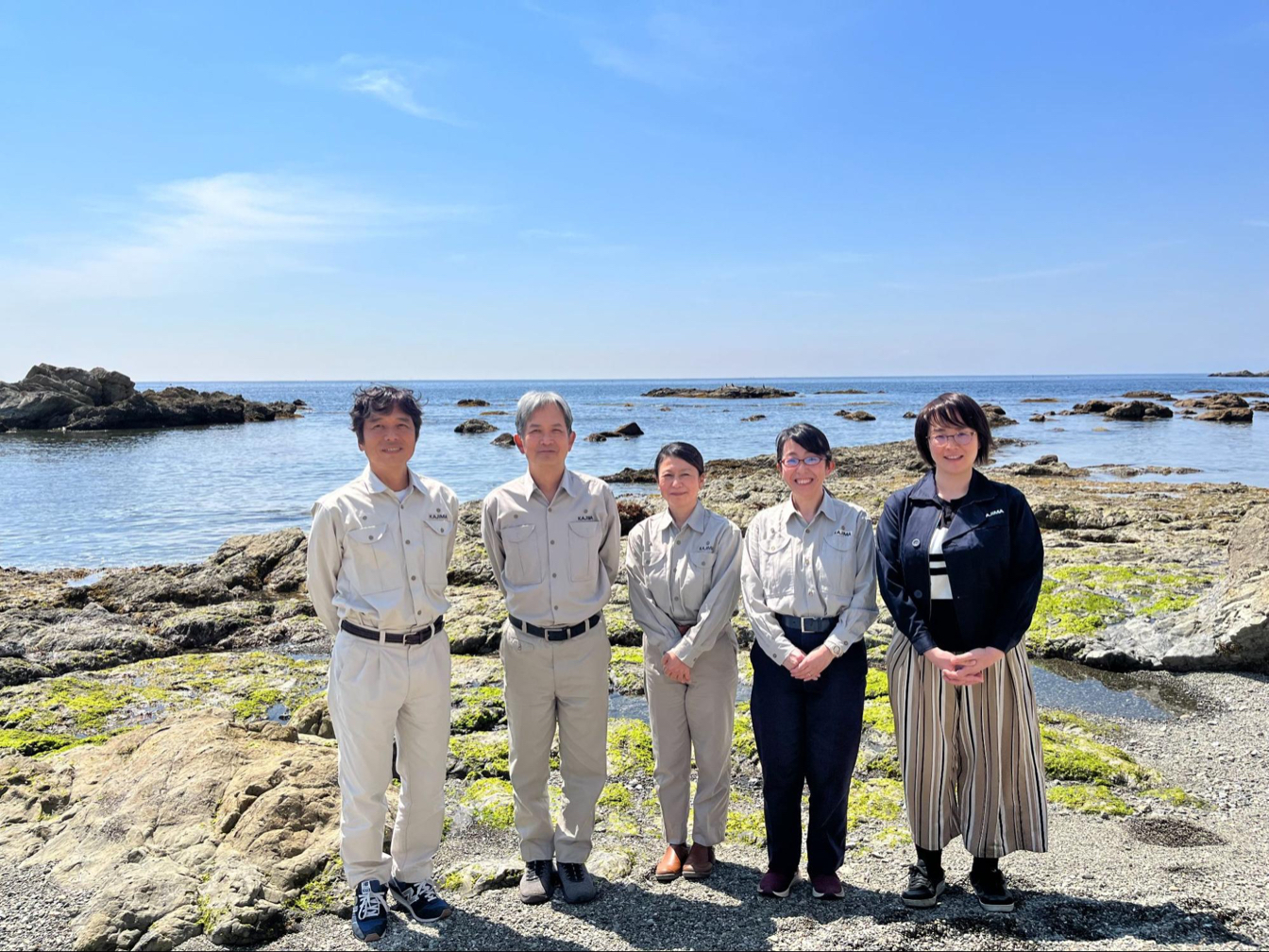 葉山水域環境実験場前の相模湾に立つ研究メンバー。左から２人めがリン上席研究員。 鹿島 提供