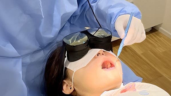 A patient wearing VR goggles and receiving treatment at a dental clinic.