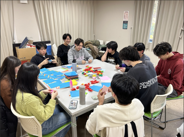 Students of the Crane Club folding paper cranes.&nbsp; &nbsp; &nbsp;Source: The Thousand Crane Club