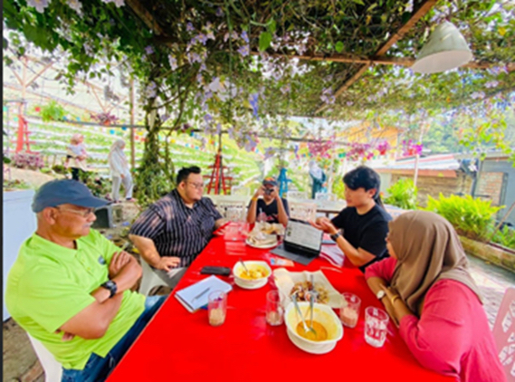 Noaki (second from right) chats with strawberry farmers in Malaysia. 