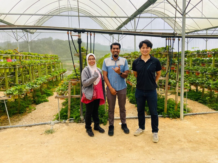 Noaki poses with farmers in Malaysia.