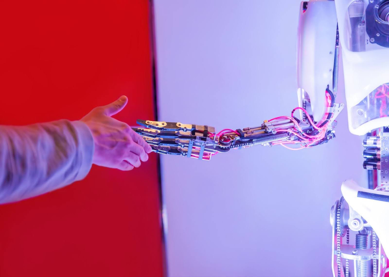 An illustration of cooperation between human and machine — a symbolic handshake marking the beginning of small-scale systems built on shared values of freedom and agency. Photo by Envato