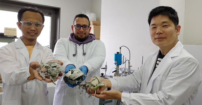AC Biode’s lab team holding samples of mixed textile and shoe waste, which they are testing for chemical recycling