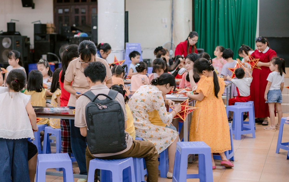 A large group of children and parents at a craft class in a community hall