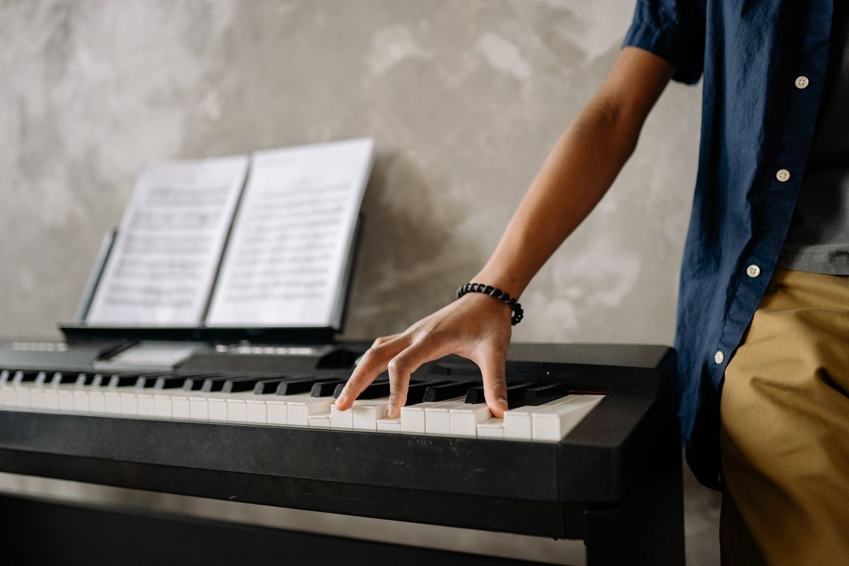 A child playing a digital piano with sheet music open on the stand