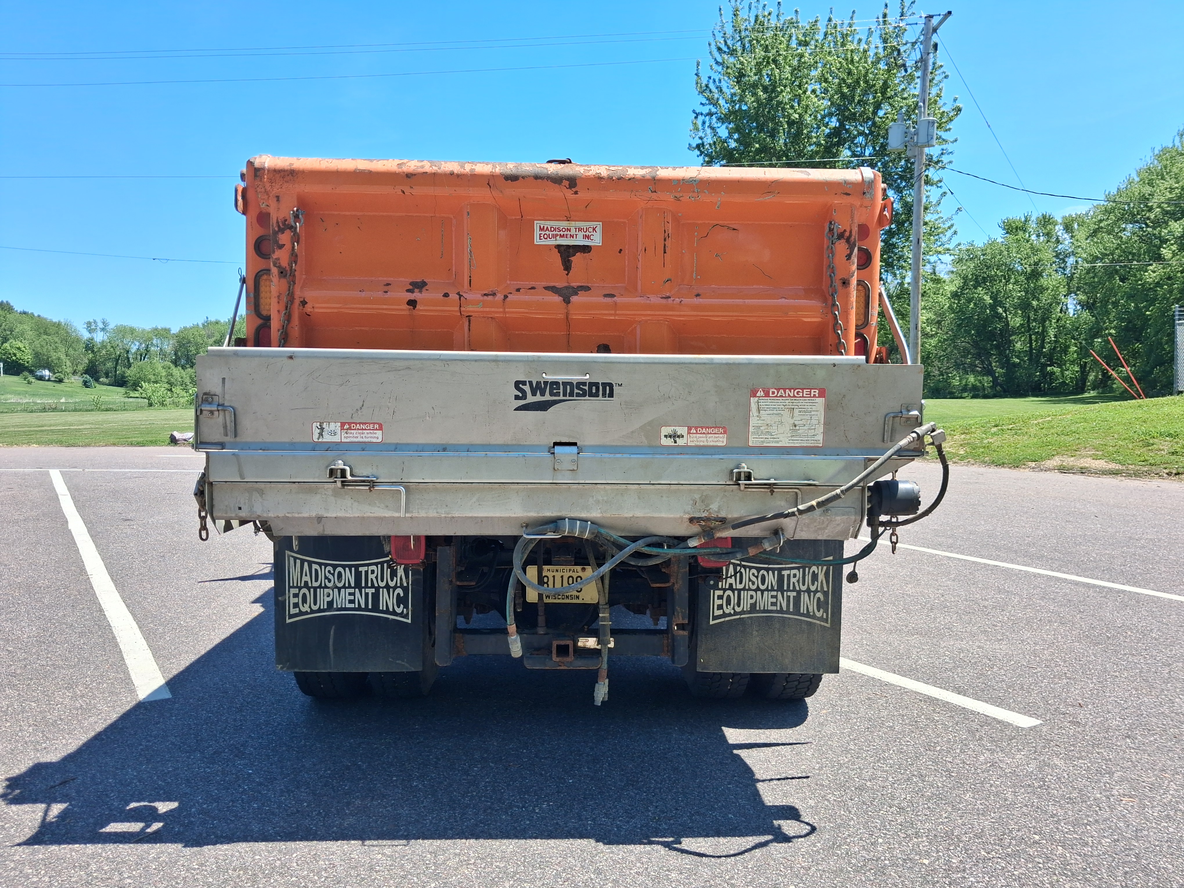 Tailgate View of Orange Dump Truck with Salt Spreader