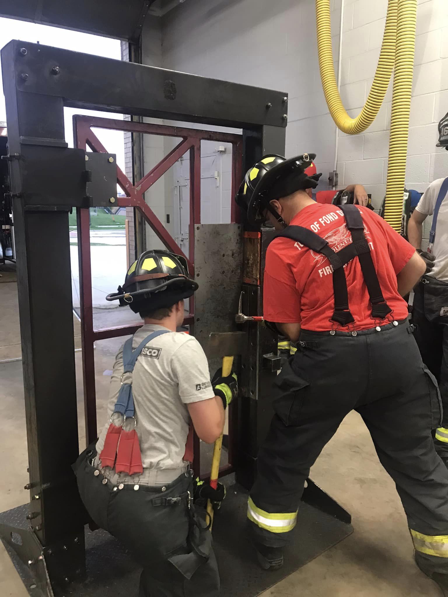 Firefighters working together on training door