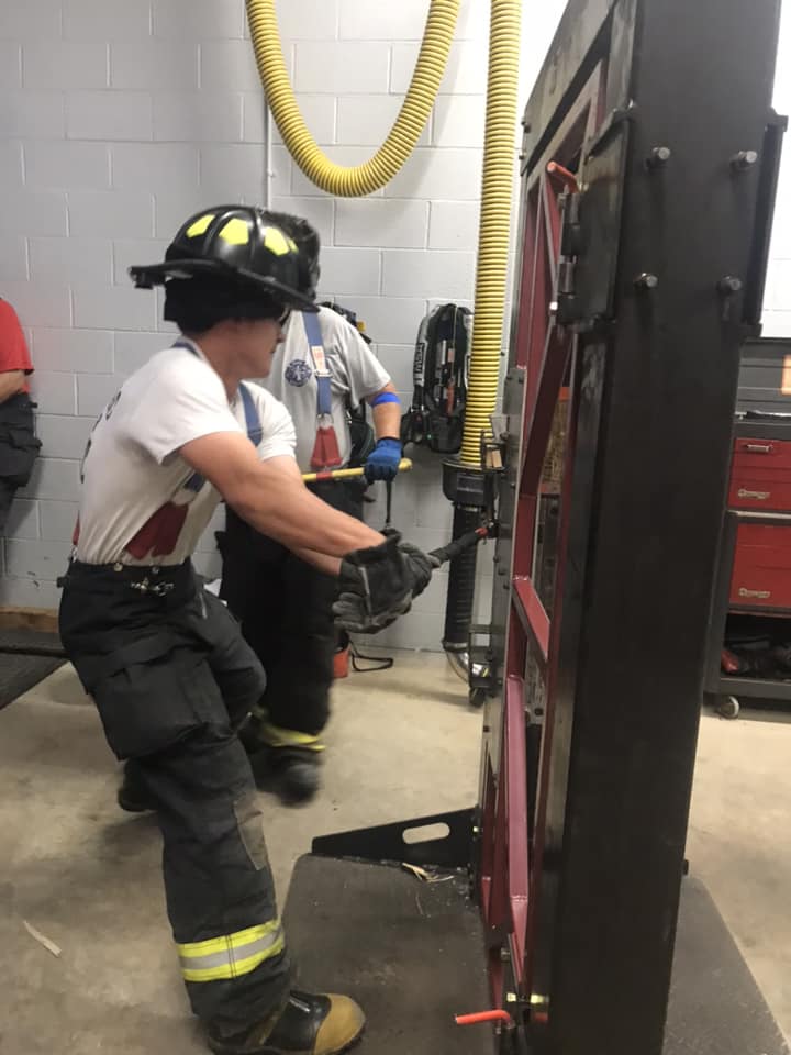 Firefighter using tools on practice prop