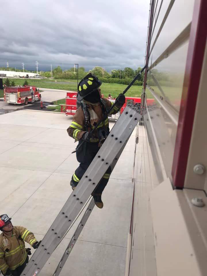 Firefighter scaling wall with gear