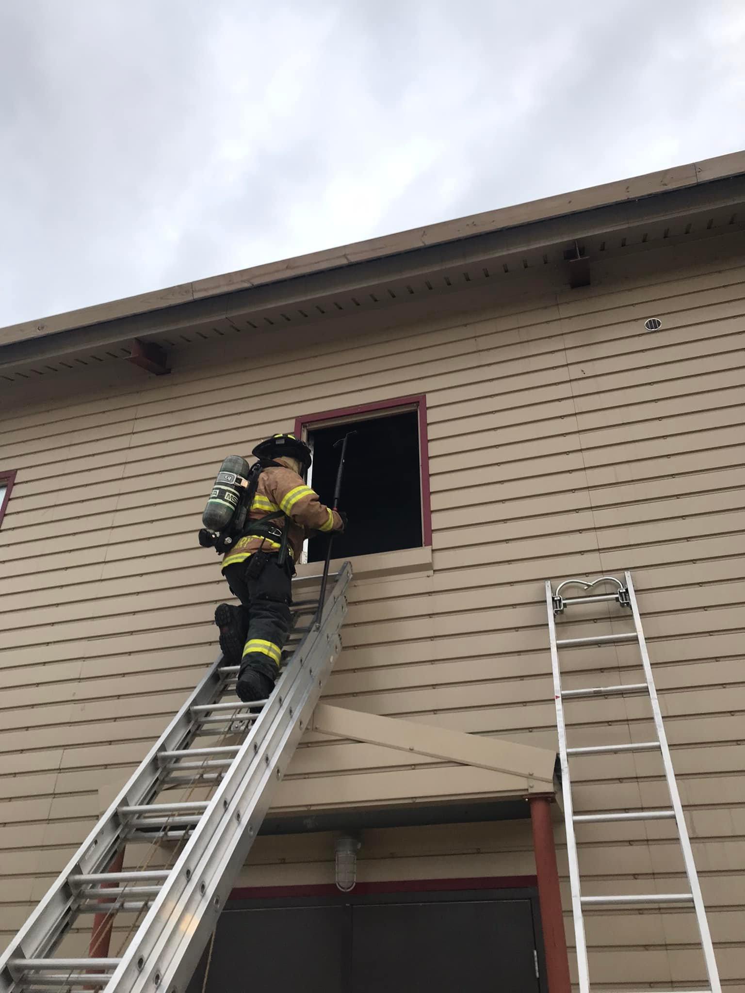 Firefighter climbing out of window