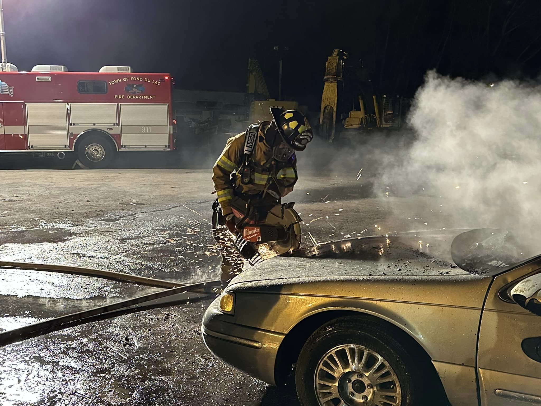 Firefighter extinguishing burning car