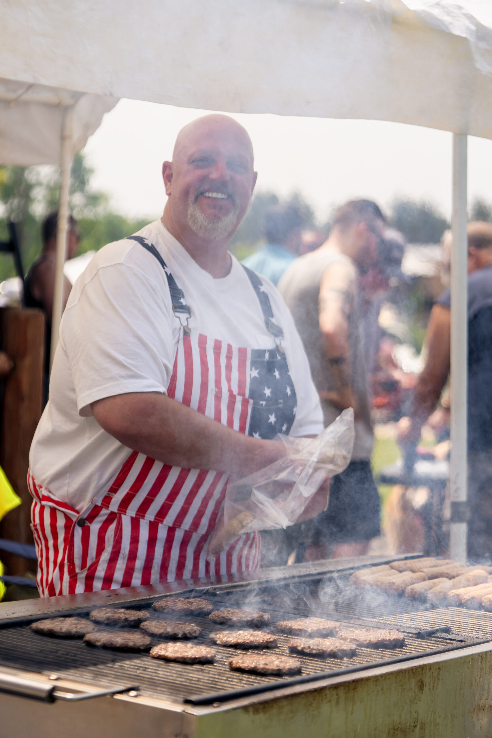 Person grilling hamburgers during an Independence Day (Fourth of July) celebration