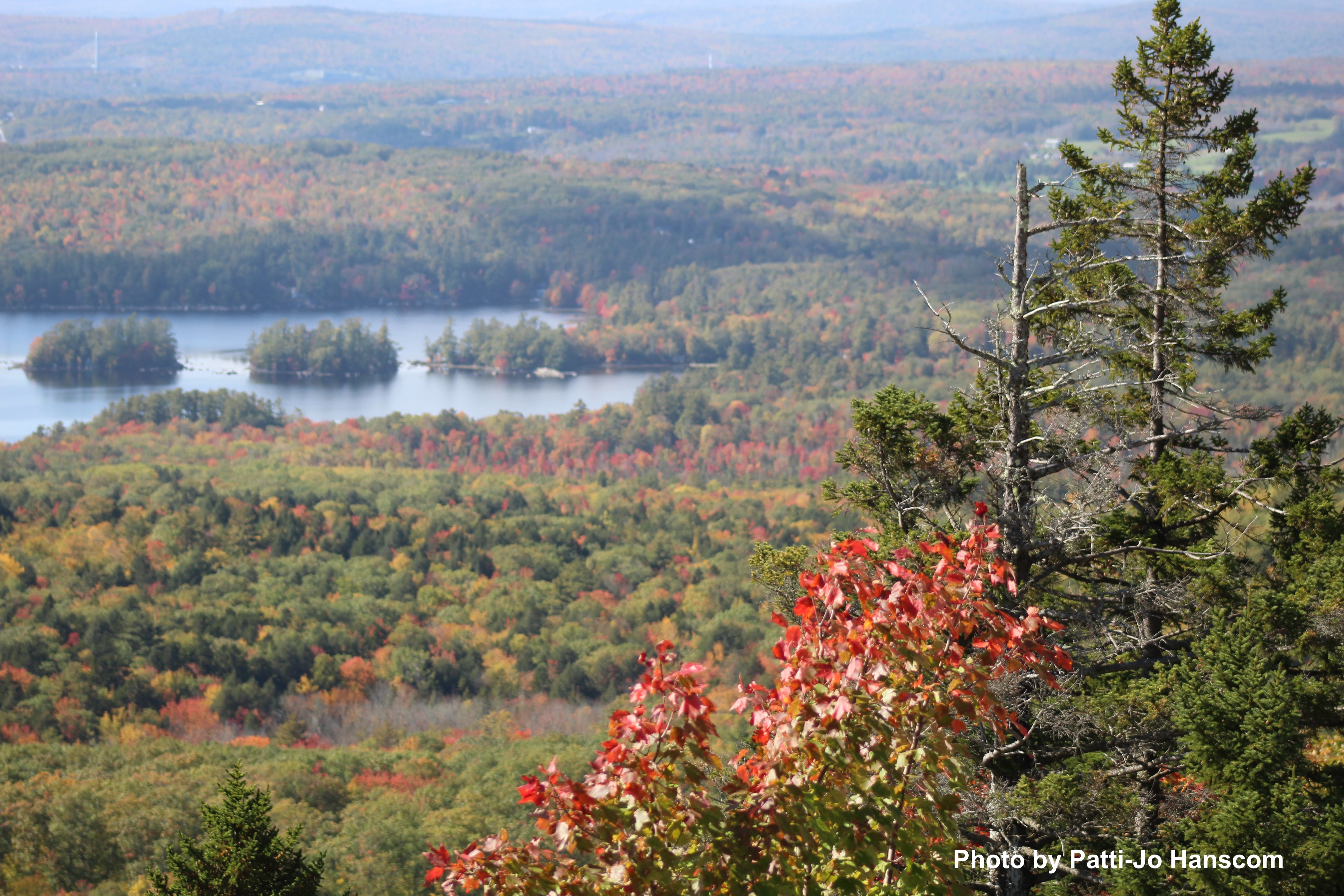 Aerial view of a Maine lake surrounded by colorful fall foliage