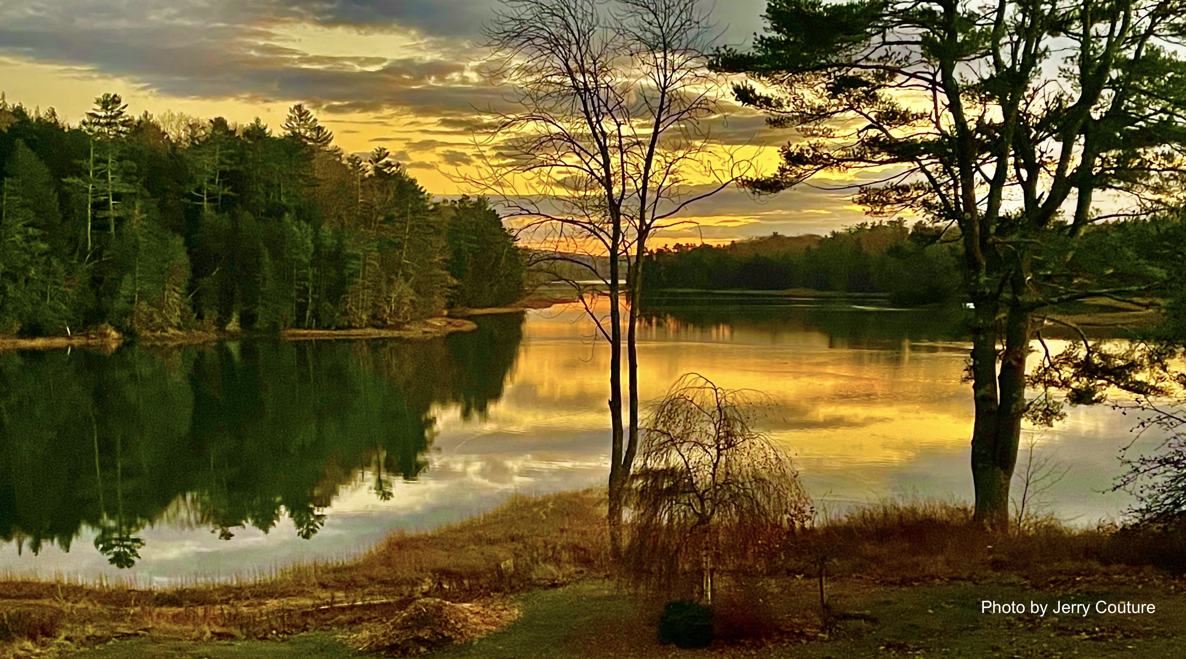 Golden sunset reflecting on the Orland River with silhouetted bare trees