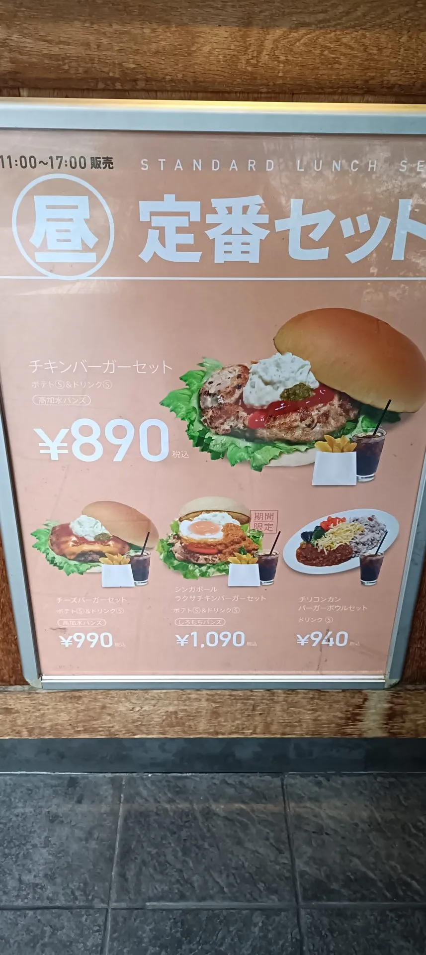 店頭の定番セットメニュー看板。チキンバーガーセット890円、チーズバーガーセット990円、シンガポールラクサチキンバーガーセット1,090円、チリコンカンバーガーボウルセット940円が並ぶ