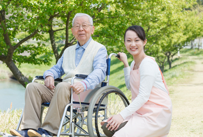 車椅子の高齢者と介護スタッフ