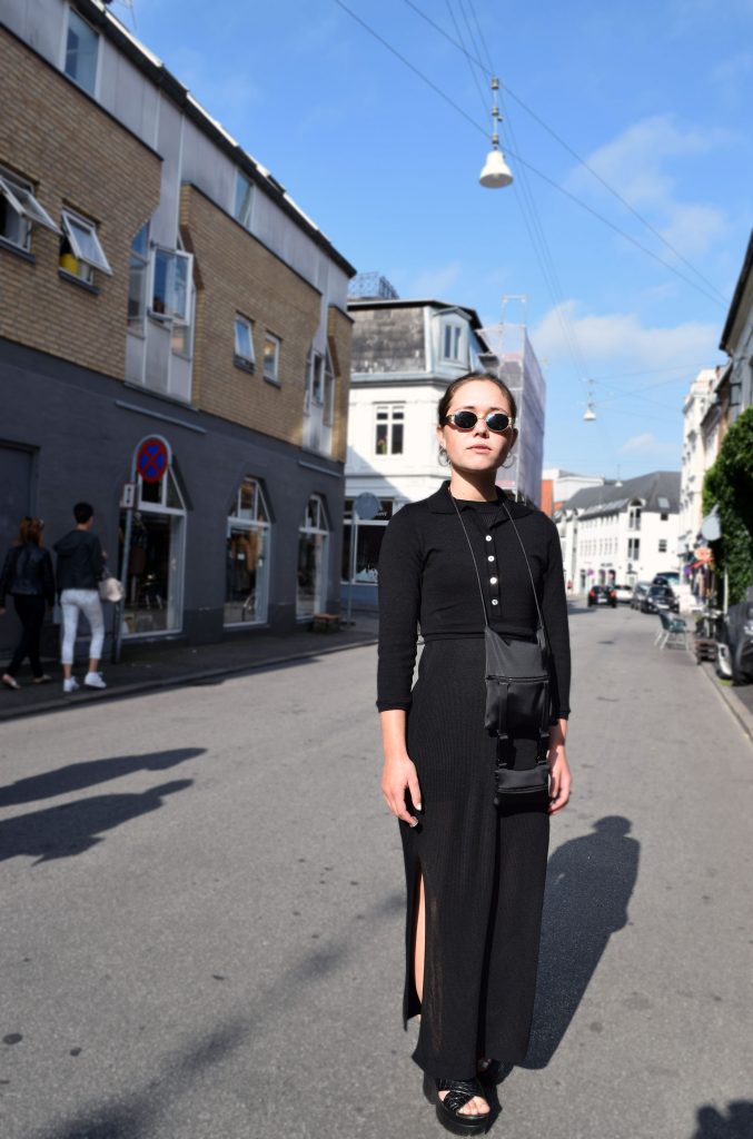 Street style danois à Aarhus, robe noires, pull noire, sandale noires et sac à bandoulière.