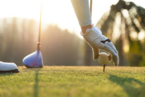 Golf ball on green grass near hole golf to win in game at golf course with sunset background.