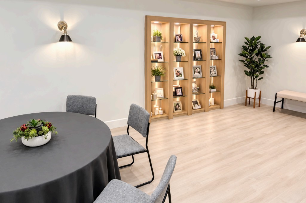 Illuminated memorial display with photographs and mementos in a warm reception setting.