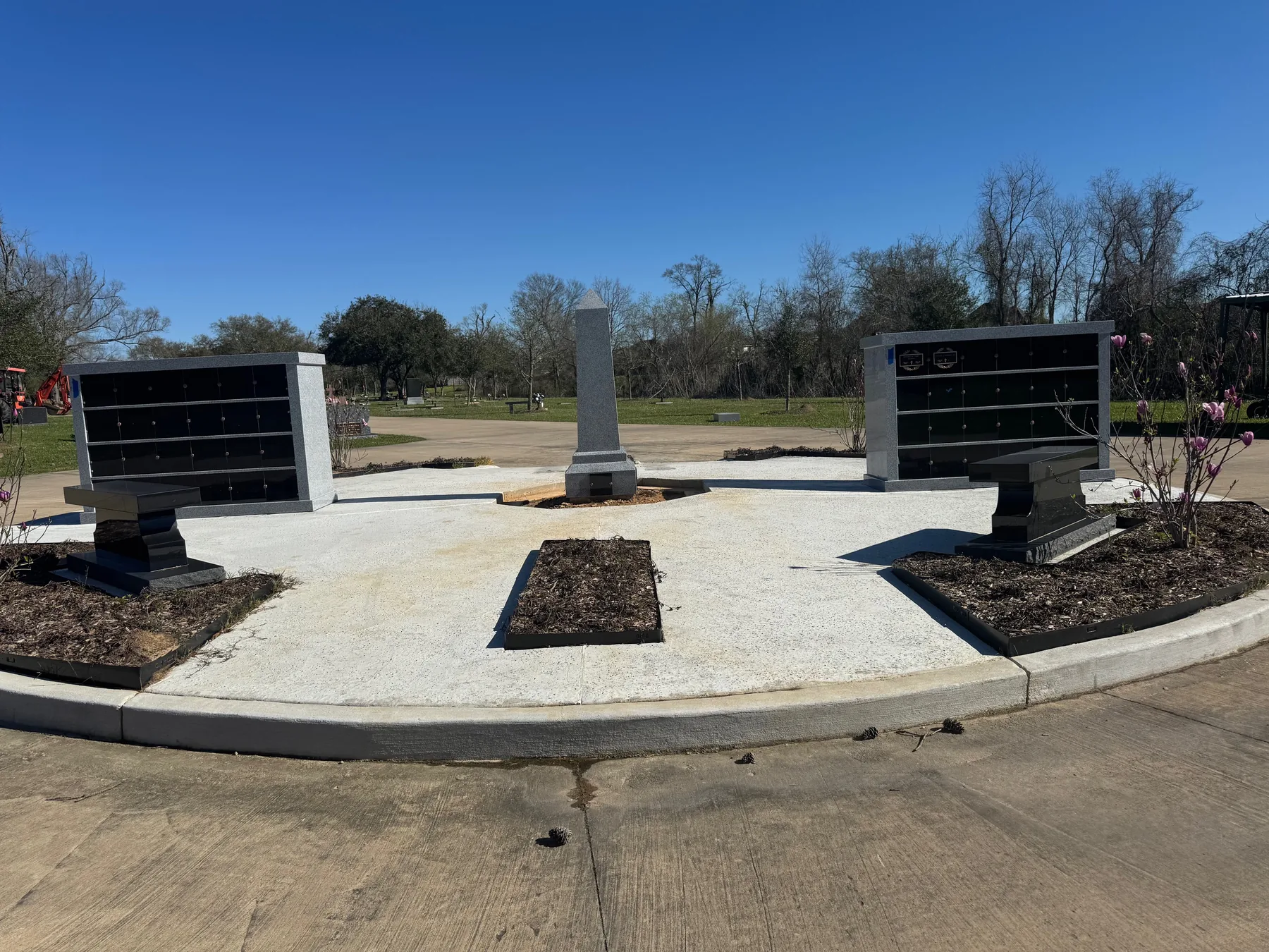 Cremation memorial garden with granite columbaria and a central obelisk at Oak Bluff Memorial Park