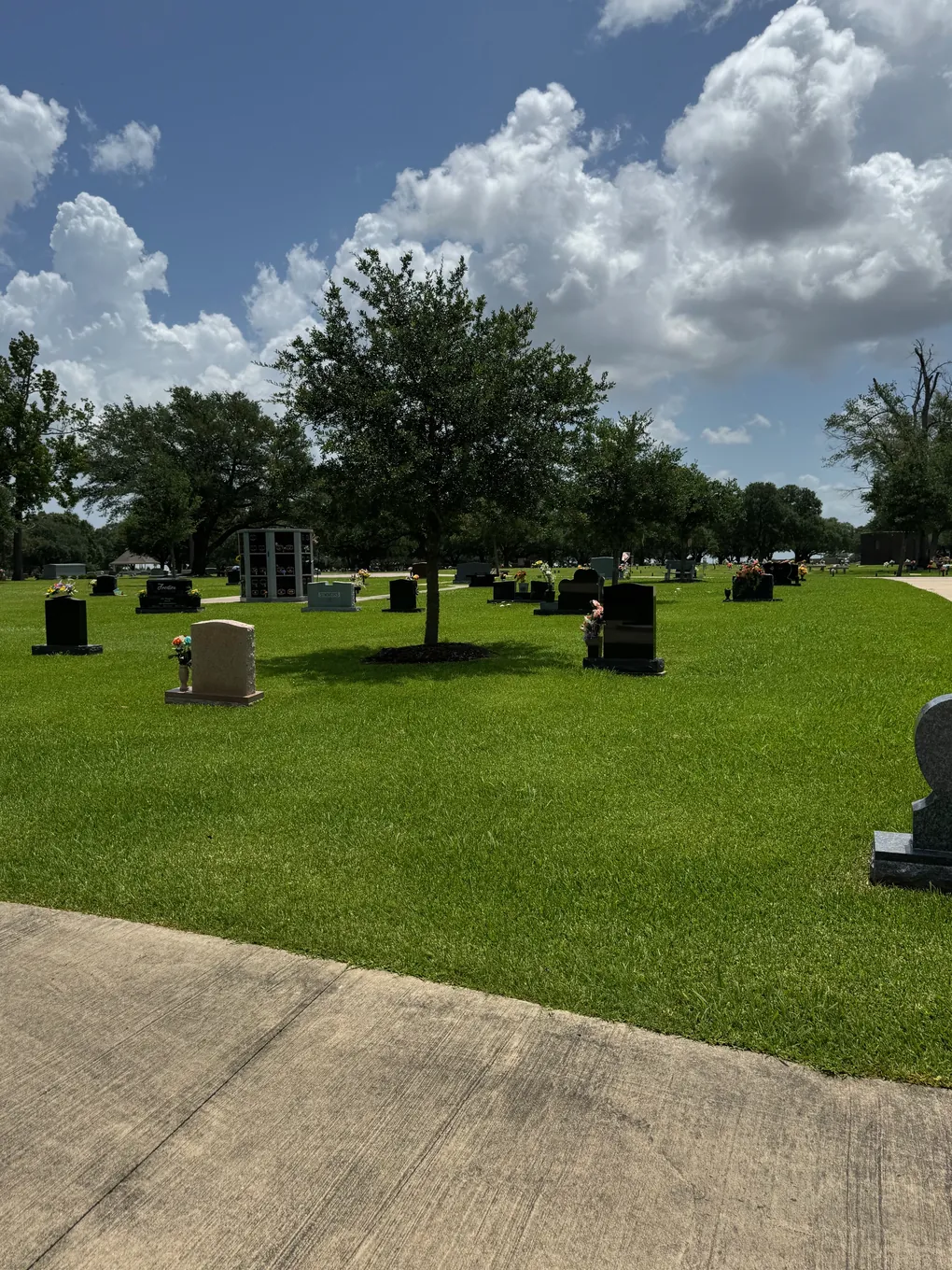 Memorial grounds with upright granite monuments at Oak Bluff Memorial Park