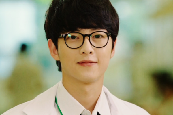 Song Joong-ki draped in a white coat wearing specs