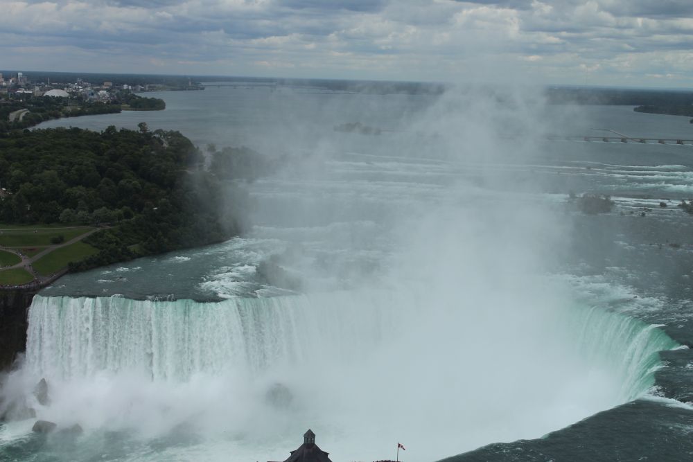 Niagara Falls on a bright day with mist rising from the gorge