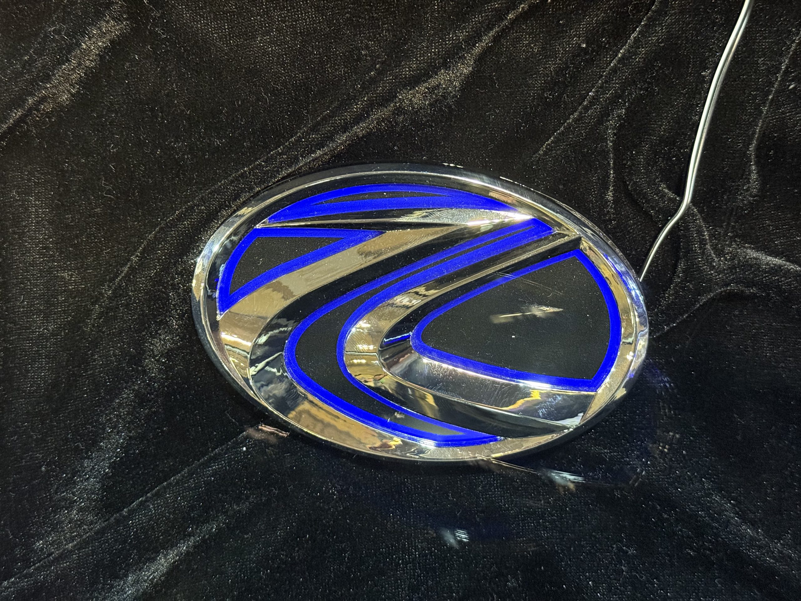 青く発光するLEDを内蔵したクローム仕上げのエンブレム本体。