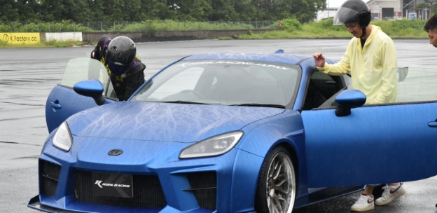 青の車に乗り込もうとする人