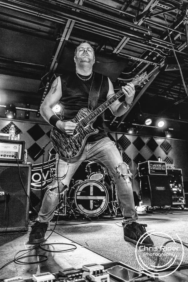 Josh Sapna playing guitar wide stage shot