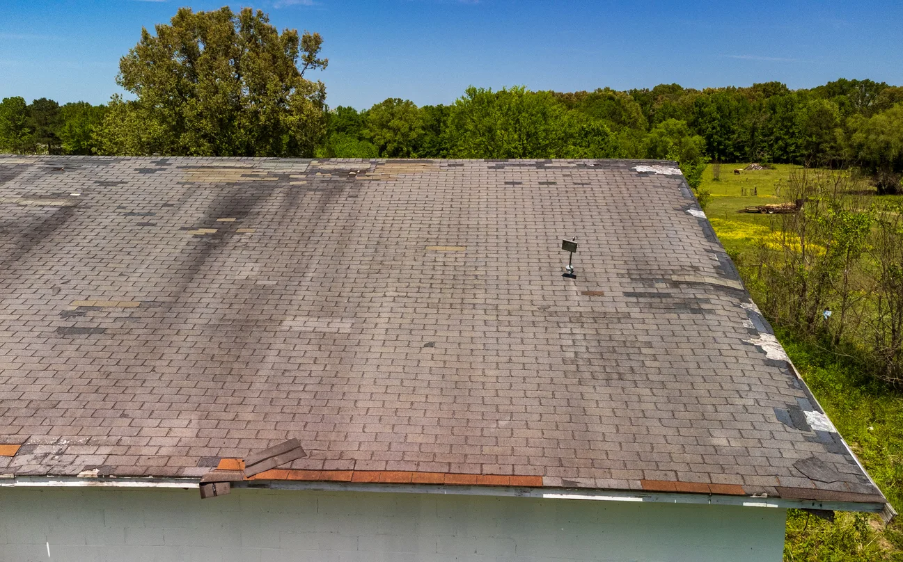 Aerial drone view of roof with missing and damaged shingles