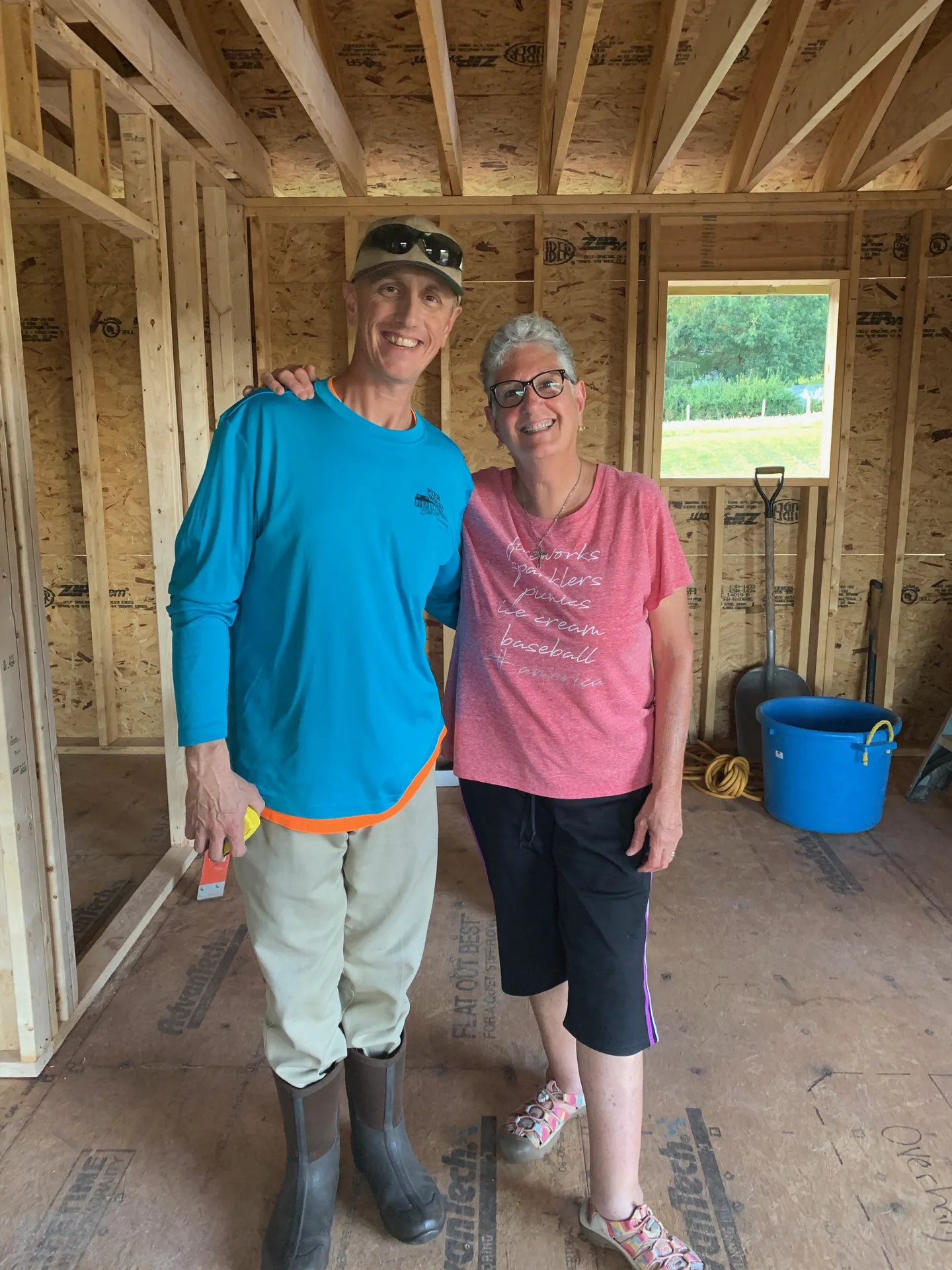 Custom home framing with happy homeowner