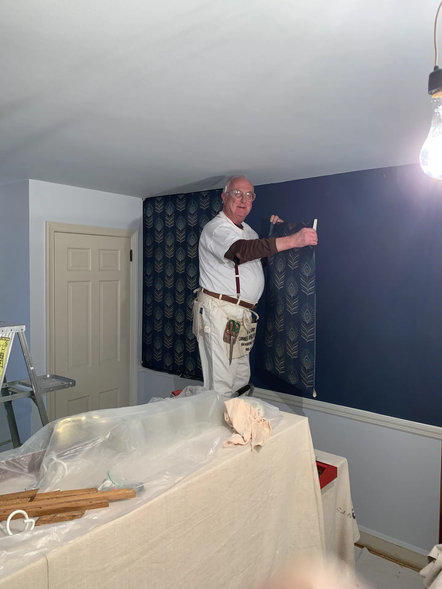 Designer wallpaper installation above chair rail