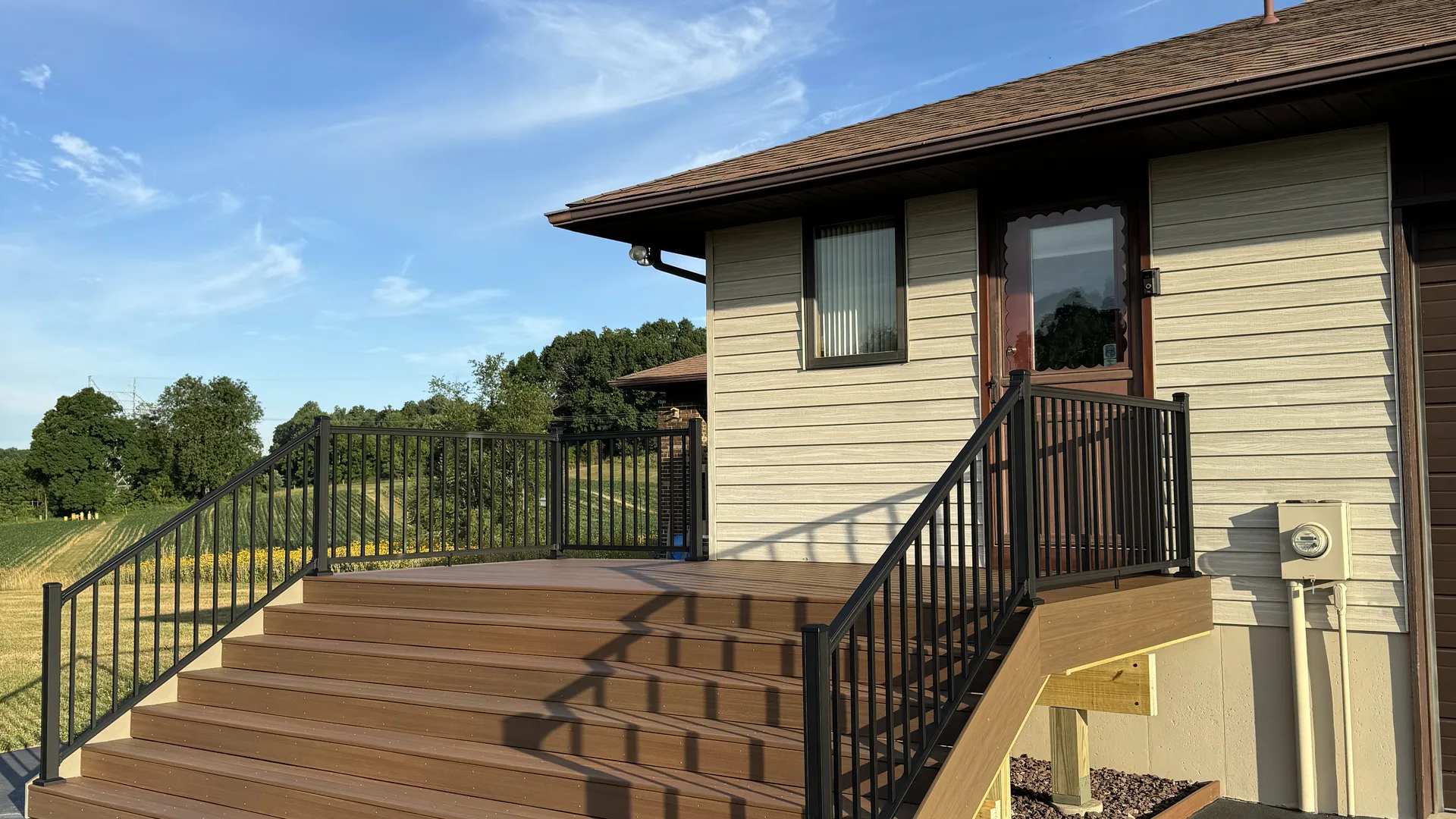 Finished composite deck with wide stairs built by Trade Masters