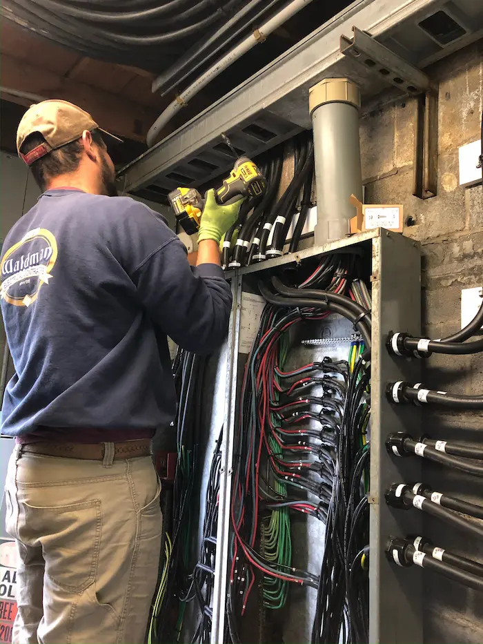 A Waldman electrician wiring a commercial electrical panel