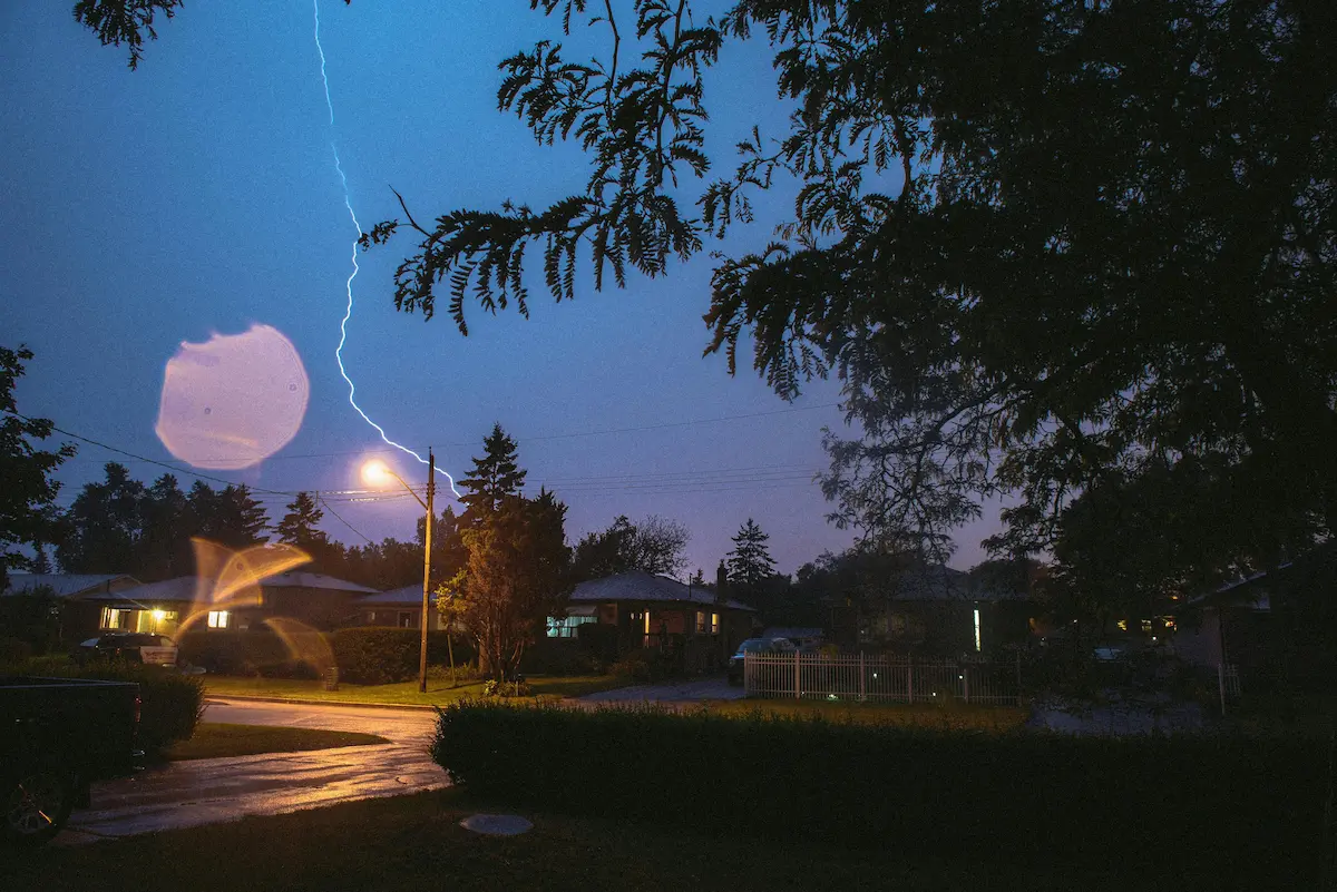Lightning striking near homes at night