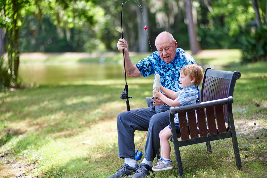 Senior man fishing with small child