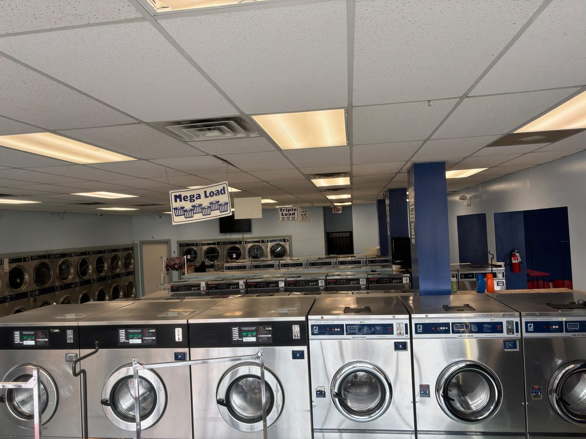 Rows of large-capacity washers and dryers on the Laundry Station floor