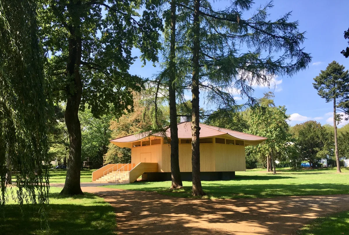 Hölzerner Pavillon im Krefelder Park, von Bäumen gerahmt, ein Ort des Innehaltens