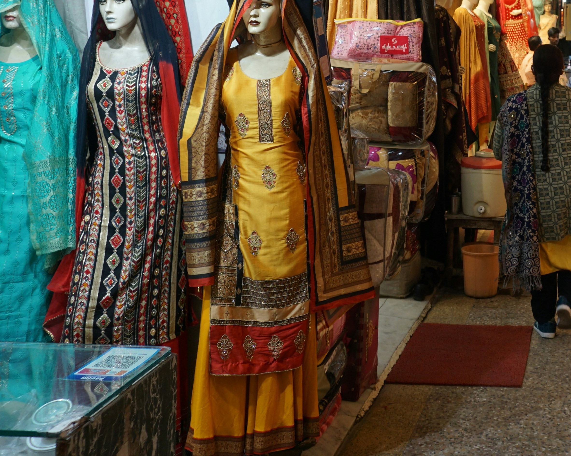 Mannequins in embroidered kurtas and dresses outside a clothing shop in Palika Bazaar