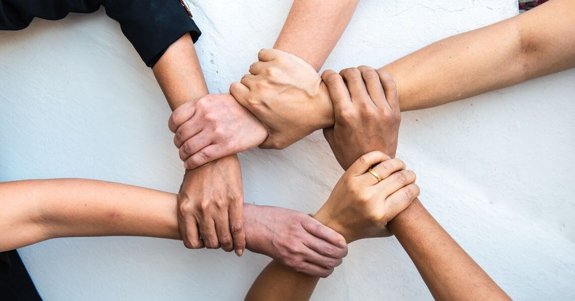 Hands holding wrists to form a connecting circle