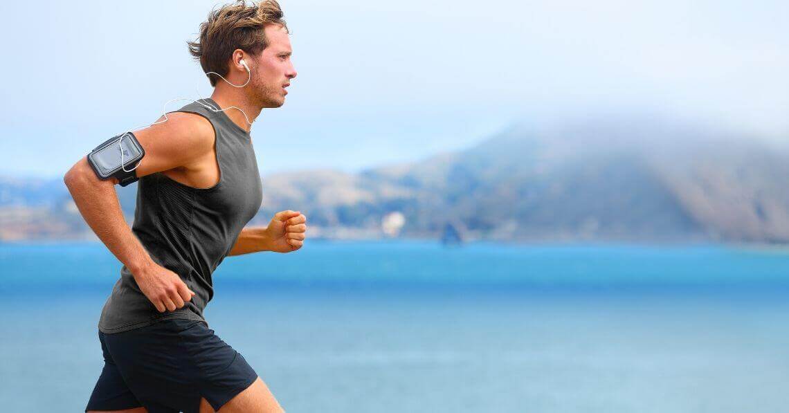 Young man running while listening to music