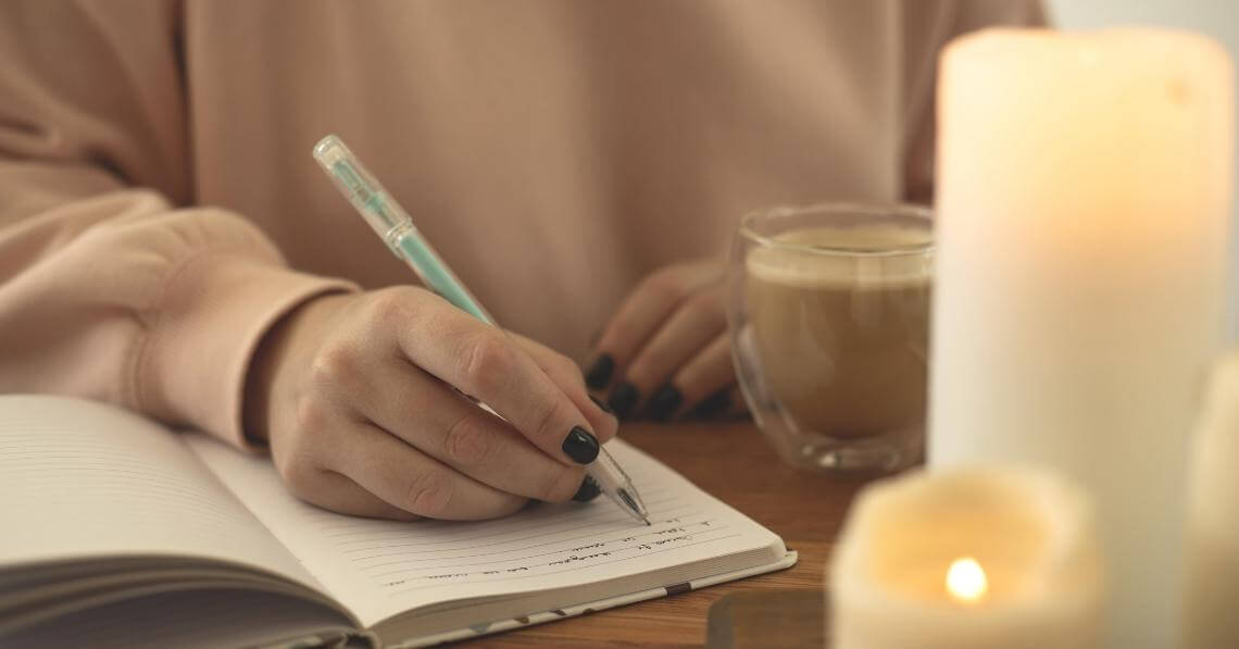 Woman writing in gratitude journal