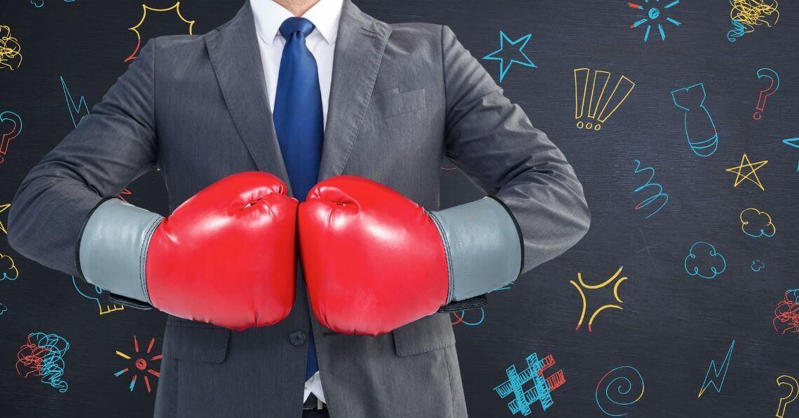 Man with boxing gloves in a suit is ready to fight