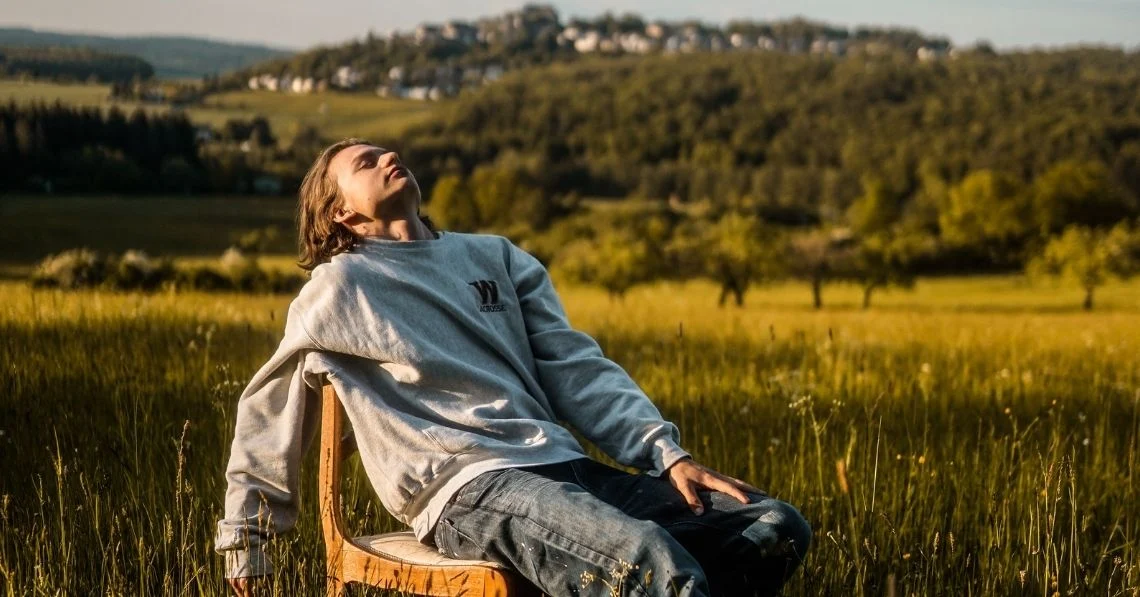 A young man relaxing in a field in the end of the summer