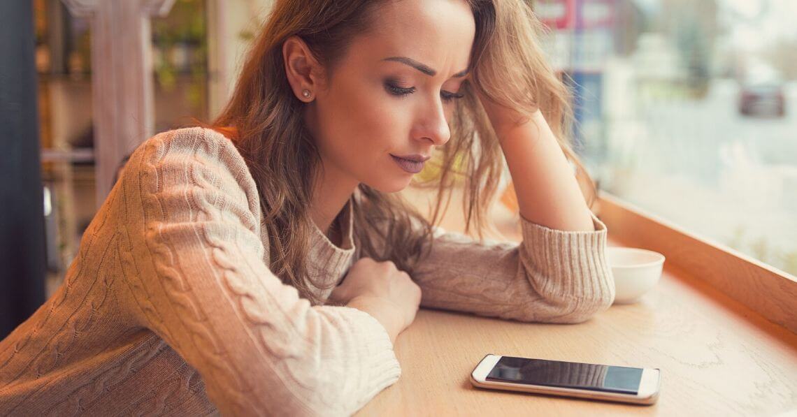 Lonely woman looking at her phone